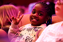 Photo of girl at concert giving the peace sign